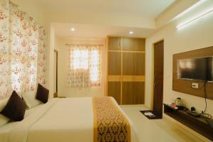 斋浦尔Hotel Cheelgadi的一间卧室配有一张大床和电视