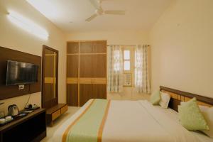 斋浦尔Hotel Cheelgadi的一间卧室配有一张大床和一台平面电视