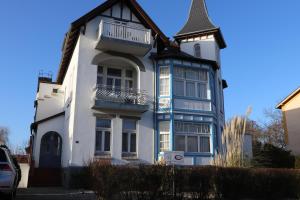 奥斯赛拜-屈隆斯博恩Pension Lotte的白色和蓝色的房子,有塔楼