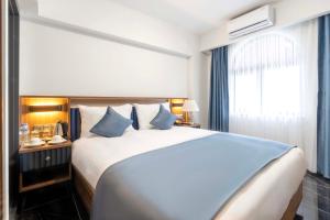 伊斯坦布尔THE BOSFOR HOTEL的卧室配有带蓝色枕头的大型白色床