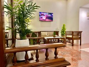比纳里姆Rosewood By The Beach Goa的一间带长凳和盆栽植物的客厅