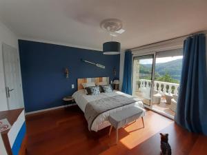 MiremontMa villa au bord de l'eau的一间卧室设有一张蓝色墙壁的大床