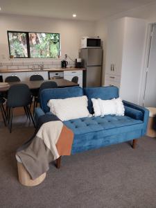 弗朗兹约瑟夫Kea Retreat的客厅设有蓝色沙发,配有厨房