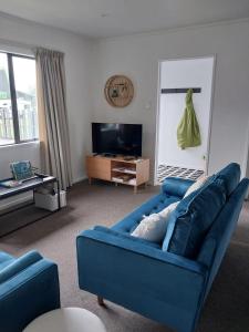 弗朗兹约瑟夫Kea Retreat的客厅配有蓝色的沙发和电视