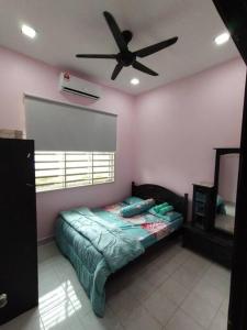 Kampong PeruntunKS Villa Homestay KKB的一间卧室配有一张床和吊扇