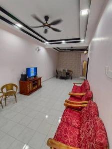 Kampong PeruntunKS Villa Homestay KKB的天花板的房间里一排红色的床