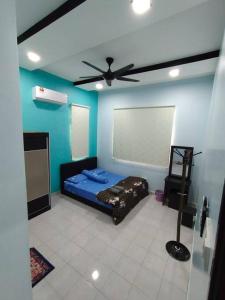 Kampong PeruntunKS Villa Homestay KKB的客房设有一张床和一个吊扇。