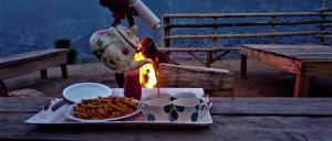 穆扎法拉巴德Kashmir Eagle Heights Cottage & Restaurant by LMC的一个人在餐桌上做饭,并带上一盘食物