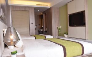 青岛青岛奥帆中心五四广场亚朵酒店的一间卧室配有两张床和一台平面电视