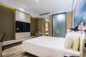 青岛青岛福州路樱花小镇亚朵酒店的卧室配有一张白色大床和一台平面电视。