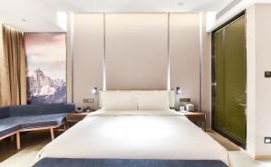 顺义北京临空新国展亚朵酒店的卧室配有一张白色的大床和一张沙发。