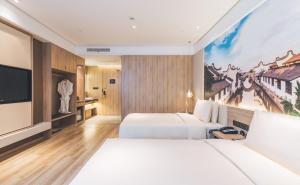上海上海新国际博览中心磁悬浮站亚朵酒店的一间酒店客房,设有两张床和电视