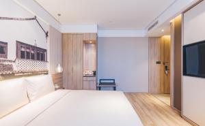 上海上海新国际博览中心磁悬浮站亚朵酒店的卧室配有一张白色大床和一台平面电视。