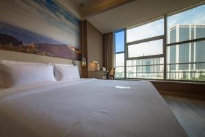 济南济南高新万达广场天辰路亚朵酒店的一张大白色的床,位于一个设有大窗户的房间