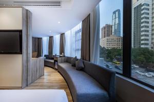长沙长沙国金中心亚朵酒店的酒店客房设有沙发和大窗户