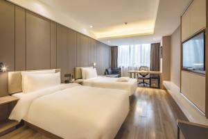 青岛青岛奥帆中心五四广场亚朵酒店的酒店客房设有两张床和电视。