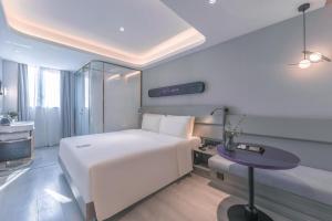 上海上海陆家嘴第一八佰伴轻居酒店的卧室配有白色的床和桌子