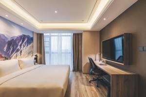 重庆重庆江北机场亚朵酒店的酒店客房配有一张床、一张书桌和一台电视。