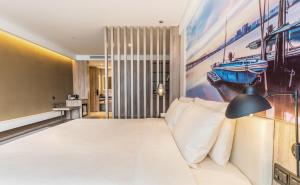 深圳深圳南山科技园科苑路亚朵酒店的卧室配有一张床,墙上挂有绘画作品