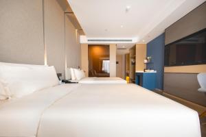 济南济南工业南路CBD亚朵酒店的一张大白色的床,位于酒店客房内