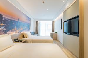 上海上海虹桥韩国街亚朵酒店的酒店客房设有两张床和一台平面电视。