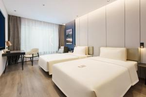 大连大连机场亚朵酒店的酒店客房配有两张床和一张书桌