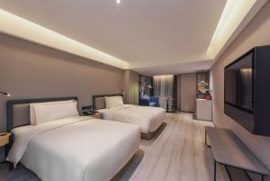 重庆重庆解放碑洪崖洞江景亚朵S酒店的酒店客房设有两张床和一台平面电视。