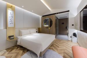 北京北京中关村北外亚朵S酒店的卧室配有白色的床和电视