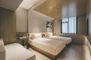 上海上海外滩南京东路亚朵轻居酒店的酒店客房设有两张床和窗户。