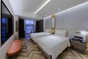 北京北京中关村北外亚朵S酒店的酒店客房设有两张床和一台平面电视。