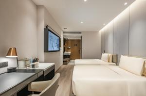 成都成都太古里春熙路步行街亚朵酒店的酒店客房设有两张床和一台平面电视。