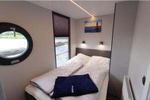 石勒苏益格Hausboot Fjord Aries mit Dachterrasse in Schleswig的一间小卧室,配有一张带窗户的床