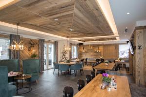 温特贝格LODGE HOTEL Winterberg的餐厅设有木制天花板和桌椅