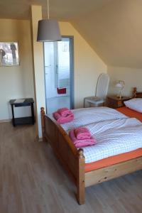 奥斯赛拜-屈隆斯博恩Pension Lotte的一间卧室配有带粉红色毛巾的床