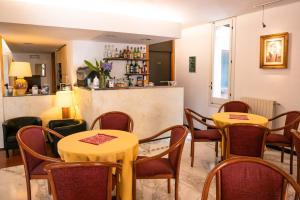 瓦拉泽Coccodrillo Hotel & Apartments的一间带2张桌子和椅子的餐厅和一间酒吧