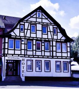 阿伦Hotel zum Weissen Ochsen的黑白的建筑,设有蓝色的窗户