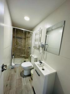 马德里HOSPEDAJE CUATRO VIENTOS的白色的浴室设有卫生间和水槽。