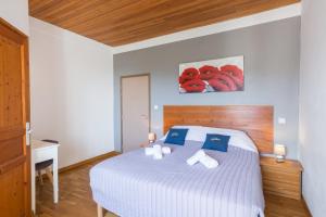 AullèneSan Larenzu的一间卧室配有白色床和蓝色枕头