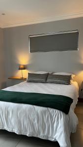 克卢夫Robyns Nest 3 Self Catering Flat的卧室配有一张带两个枕头的大白色床