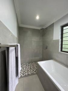 克卢夫Robyns Nest 3 Self Catering Flat的白色的浴室设有浴缸和窗户。