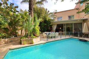 荷兹利亚Luxury villa with a heated pool, Jakuzi and a sea view 70m from the beach的棕榈树屋前的游泳池
