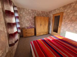 萨克森自由州诺伊斯塔滕Ferienwohnung Weber的一间卧室配有一张床和一个木制橱柜