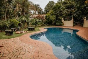 哈拉雷Amanzi Lodge的环绕着酒店的砖砌小径的游泳池