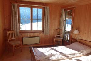 阿尔瓦努Ferienhaus Bensel的一间卧室配有一张床、两把椅子和一个窗户