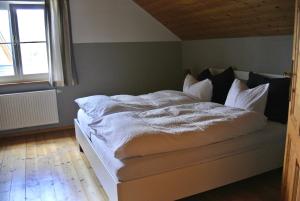 格伦德尔湖Ferienhaus Archkogl的一间卧室配有一张带白色床单的床和一扇窗户。