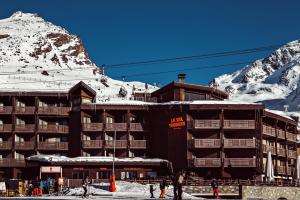 葱仁谷Le Val Thorens, a Beaumier hotel的雪覆盖的山前的滑雪小屋