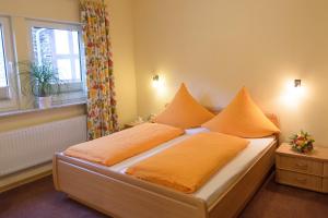 科赫姆Gästehaus Aladin的一间卧室配有带橙色床单的床和窗户。