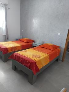 萨利波图尔Keur M et M的两张带彩色床罩的床