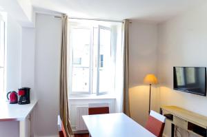 波尔多Sainte Catherine - Duplex 1 chambre的一间设有白色桌子和窗户的客房
