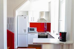 波尔多Sainte Catherine - Duplex 1 chambre的厨房配有白色冰箱和微波炉